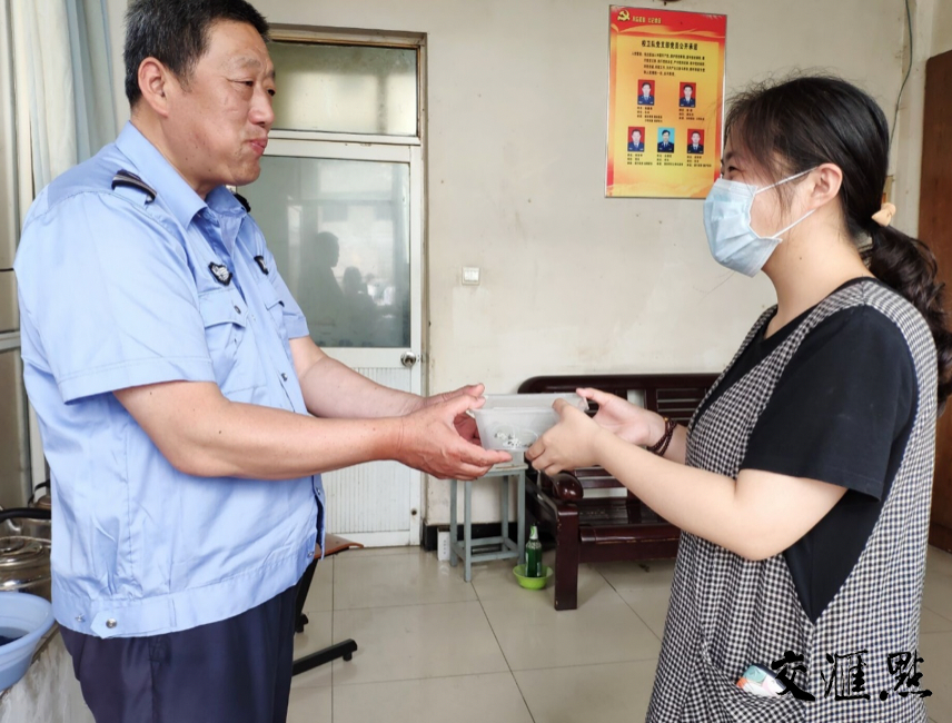志愿者将包好的粽子送给学校疫情防控一线的门卫同志